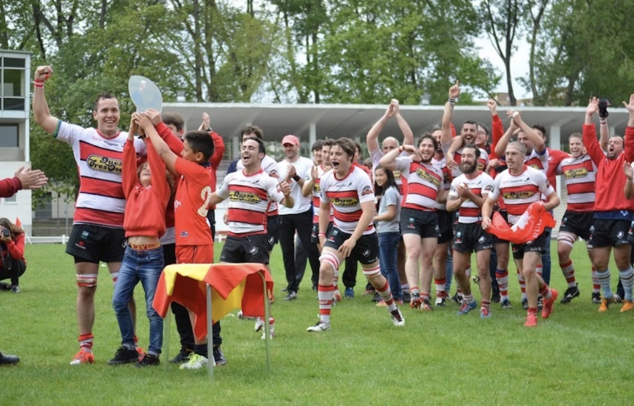 Jugadores y afición del Gijón Rugby Club celebran juntos sobre el césped